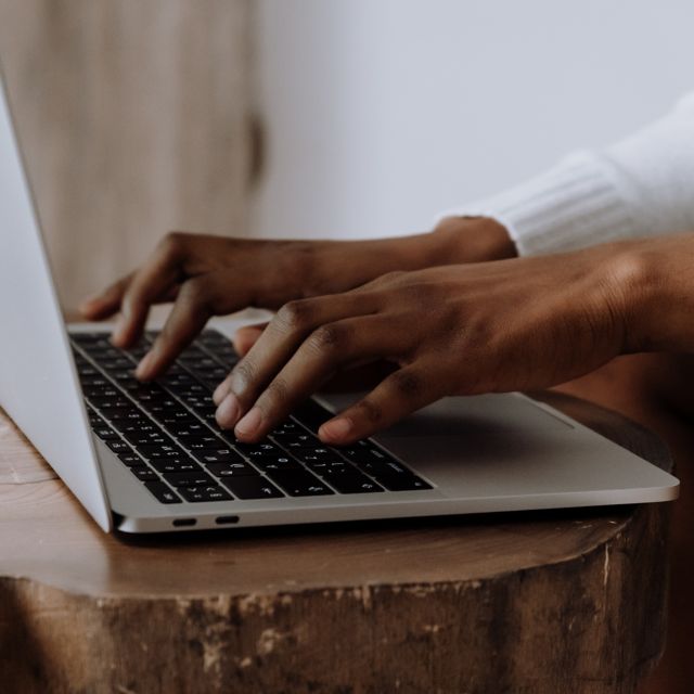 Hands typing on a laptop keyboard.