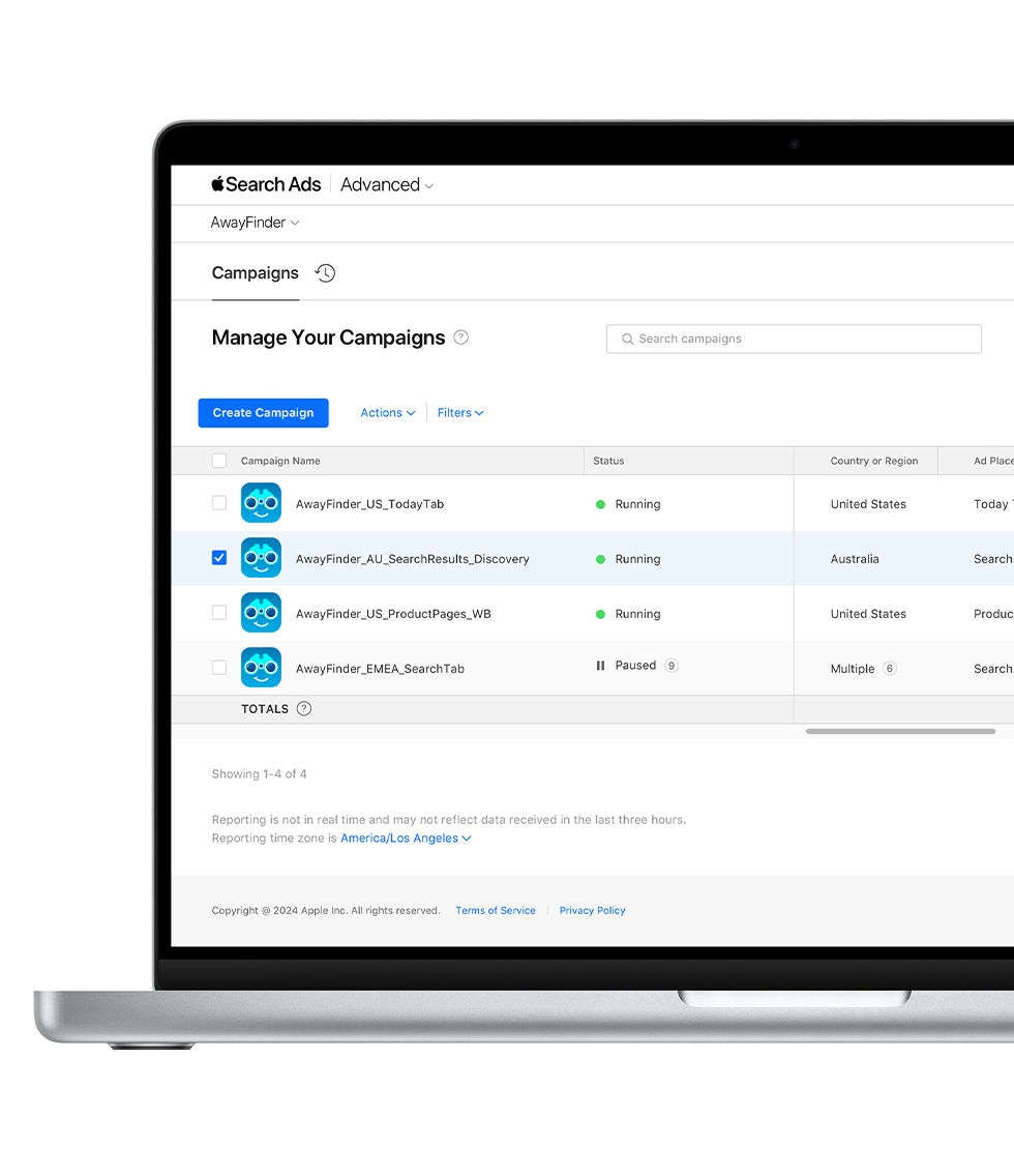 A MacBook is open to the Campaigns dashboard in Apple Search Ads Advanced. Four campaigns are listed with their campaign name, status, country or region, and ad placement appearing in columns.