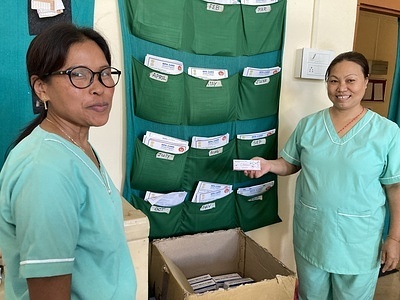 Auxiliary nurse midwives and Ms Anjana Chantang and Ms Jadin Tangsang before a ‘tickler bag’ containing records of women receiving free doses of the injectable reversible contraceptives (Depot Medroxy Progesterone Acetate (DMPA) or Antara, as it is known in India) every three months at Community Health Centre Chongkham in Namsai district, Arunachal Pradesh . Apart of digital records, the hospital staff uses tickler bags to follow up with women who are overdue for their next DMPA dose. 