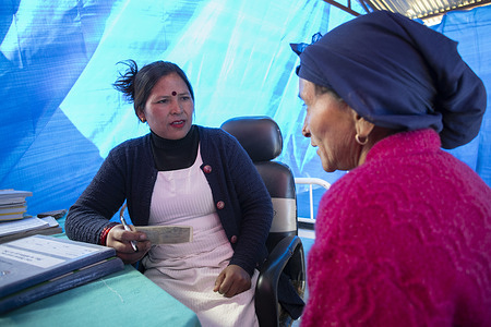 Bishnu Maya Katamat (Auxiliary nurse midwife) doing a medical inspection of a patient inside the temporary waiting room at Barekot - 2, Limsa, Jajarkot on Nov 28, 2023.