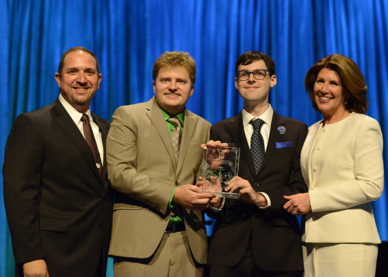 Ernie Merlan, Shane Mckaskle, Michael Yochim and Sherrie Westin pose for a photo while holding up an award.