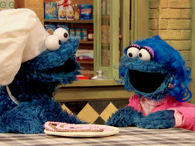 Cookie Monster with his mom, showing a heart-shaped cookie.