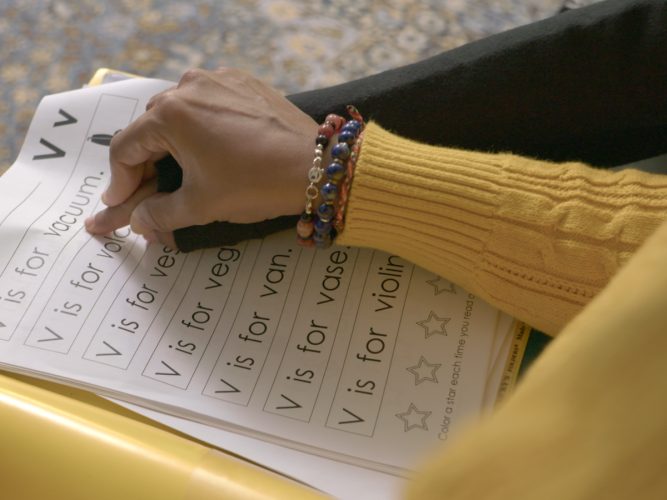 A teacher teaching a child to read.