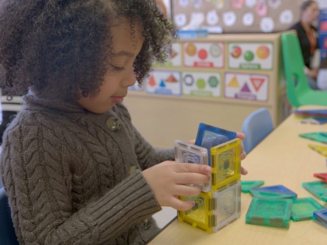 A preschooler playing with blocks.