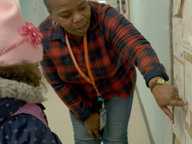 A teacher talking to a child.