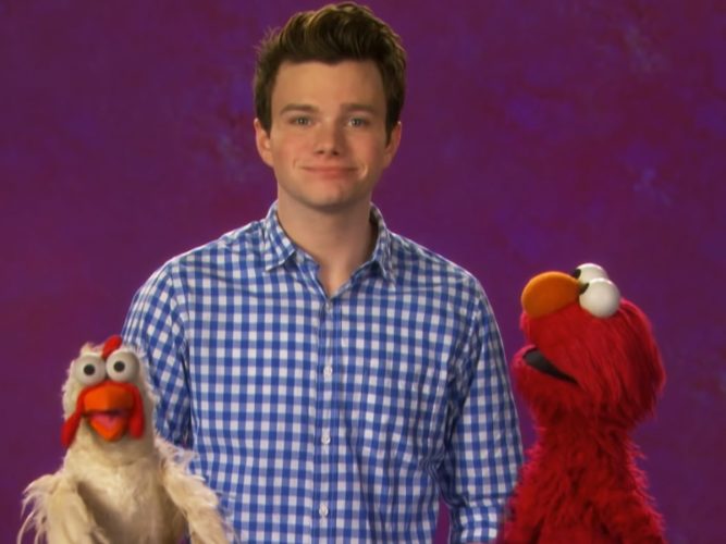 Chris Colfer with a chicken and Elmo.