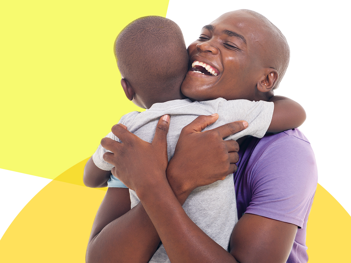 A parent hugs their child with a big smile