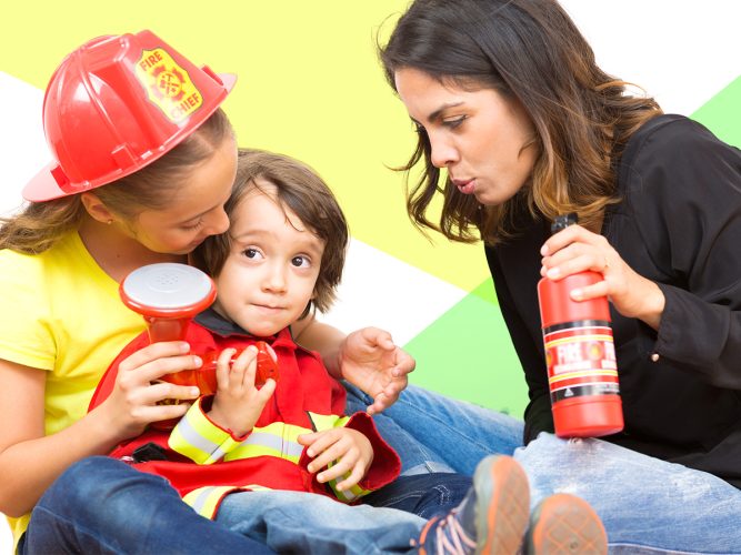 A parent plays with her children dressed like firefighters