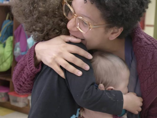 A parent holding two children.