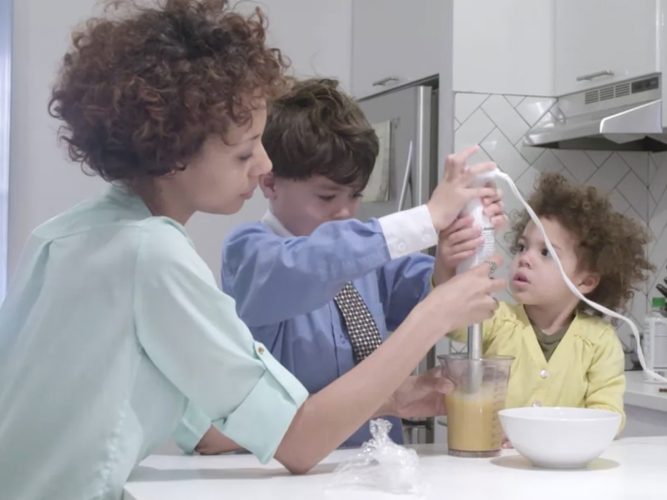 Two children cook with a parent