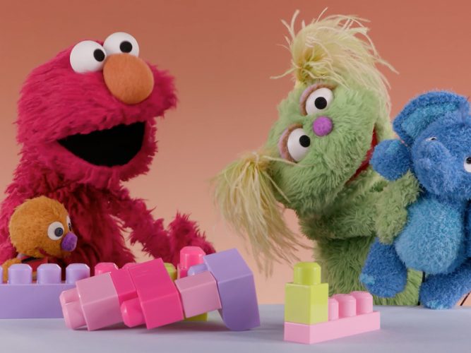 Karlie and Elmo playing with blocks.