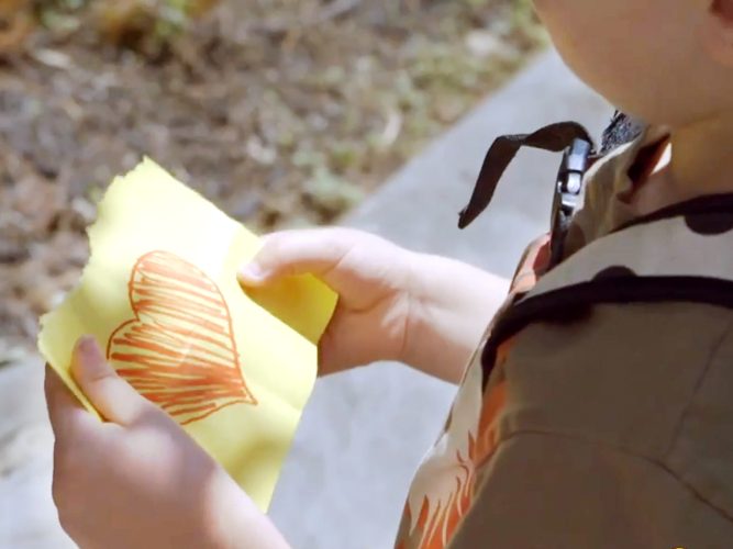 A child holding a piece of paper with a heart on it