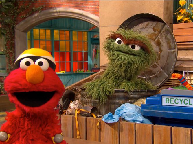 Elmo talking to Oscar the Grouch.