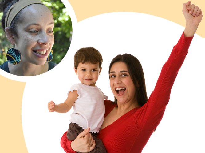 A Parent holding their child and celebrating with their hand in the air.