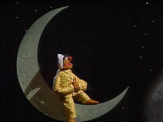 Ernie sitting on the moon in his pjs.