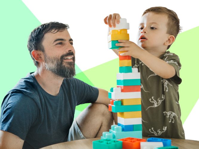 A parent and child building a block tower.