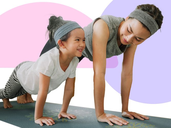 A parent and child on a yoga mat doing planks.