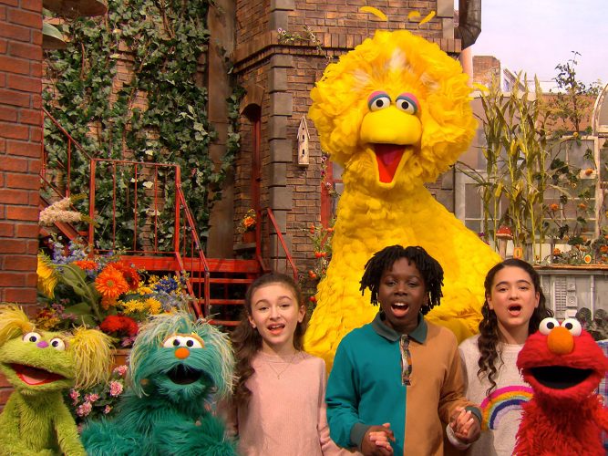 Big Bird and friends singing on Sesame Street.