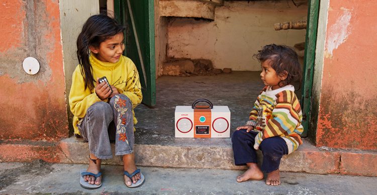 Two children listening to a radio.