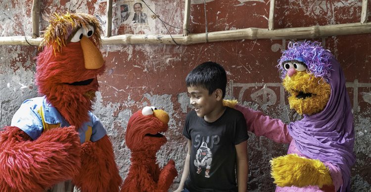 Elmo, Louie and Mae with a child.