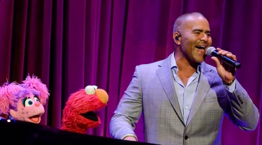 Chris Jackson singing with Elmo and Abby.