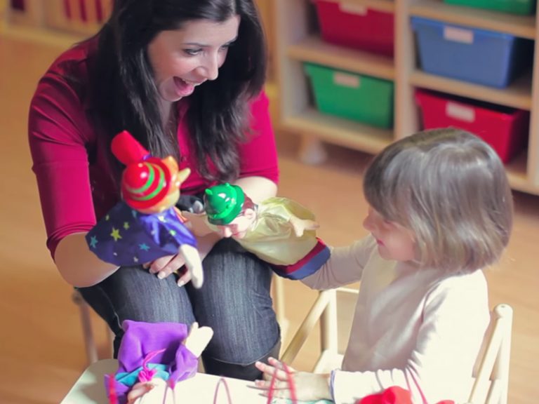 And adult plays with puppets with a child.