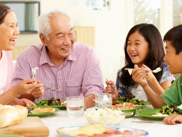 Two grandparents enjoy a meal with their grandchildren.