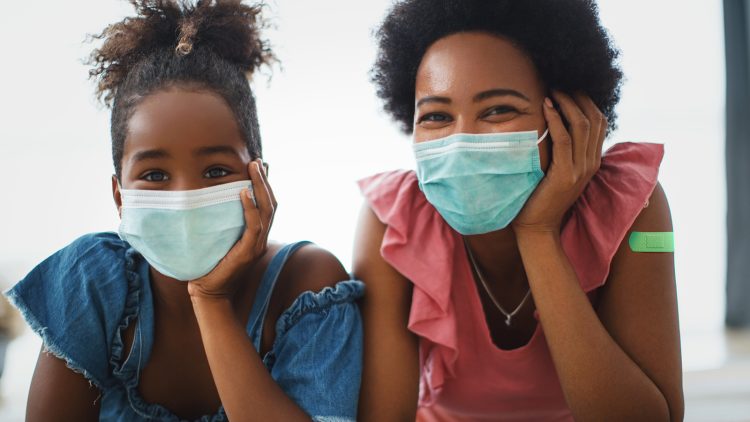 A mother and daughter wearing protective masks together.