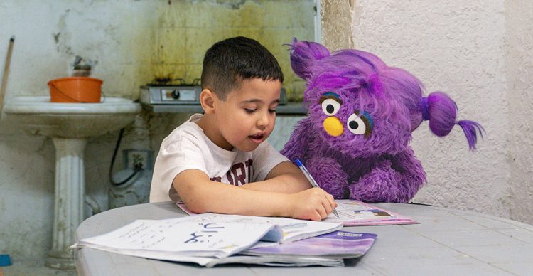 Basma doing school work with a child.