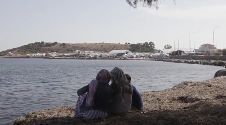 A family sitting by a lake.