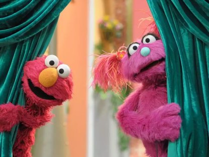 Bel and Elmo peeking from behind a curtain.