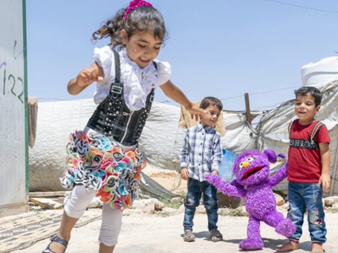 Basma playing hop scotch with kids.