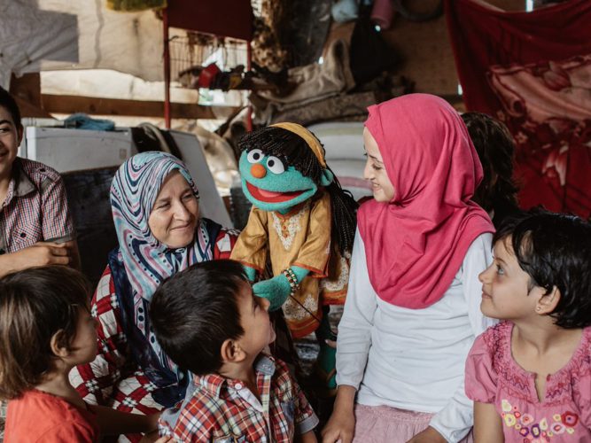 Raya talking to a group of kids.