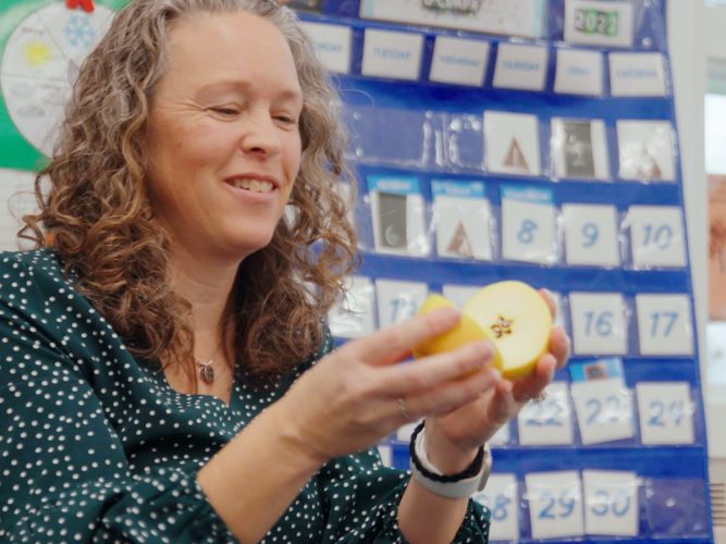 A teacher introduces a fruit to her class