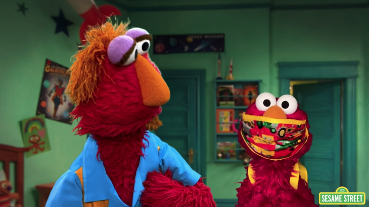 Elmo is with his dad, Louie, wearing his backpack and a facemask.