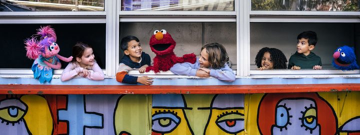 Children by artwork with Elmo and Abby.