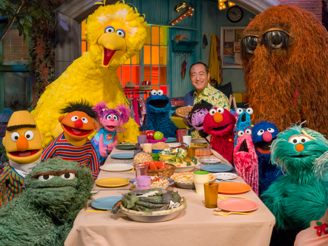 The Muppet's of Sesame Street at a long dinner table.