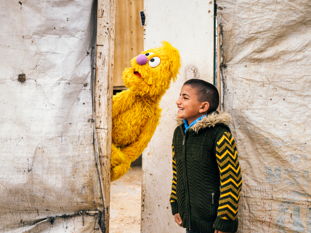 Jad and a child smiling outside.