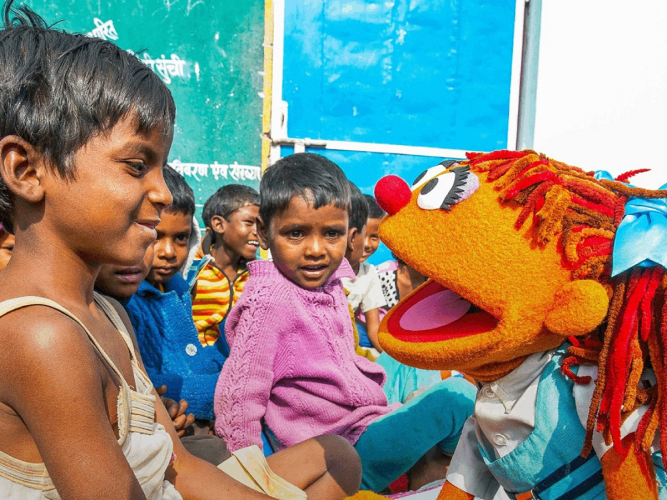 Chamki smiling with children.