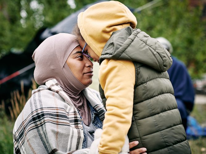 Child and adult touching their heads together.