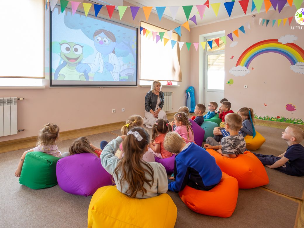 Kids on beanbag chairs in a classroom watching Sesame Street