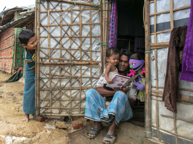 A family reading together outside.