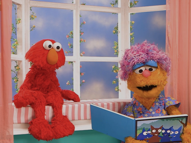 Mae reading to Elmo.