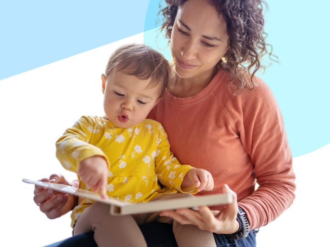 A parent and their toddler read a book together.