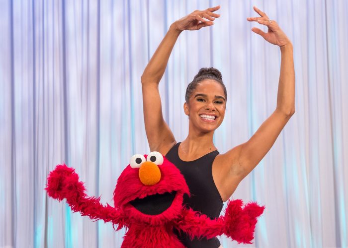 Elmo is dancing with a ballerina.