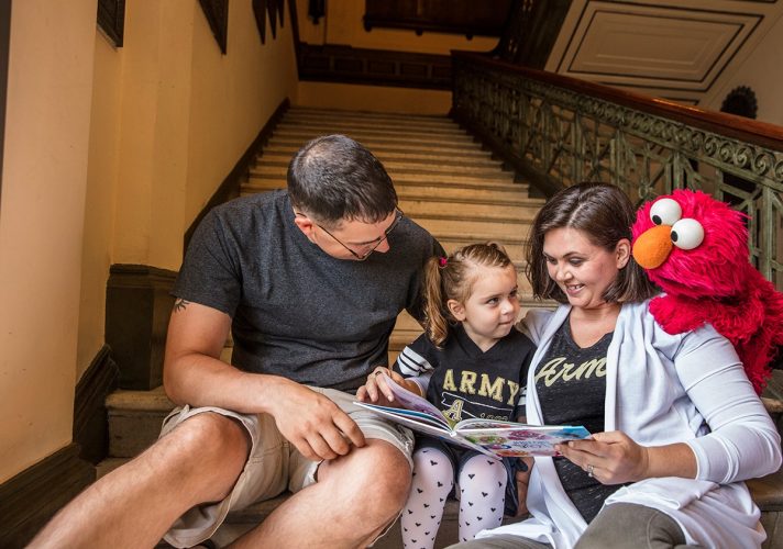 Elmo and a family reading.