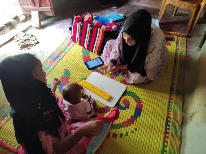 Teacher with a parent and child on a mat.