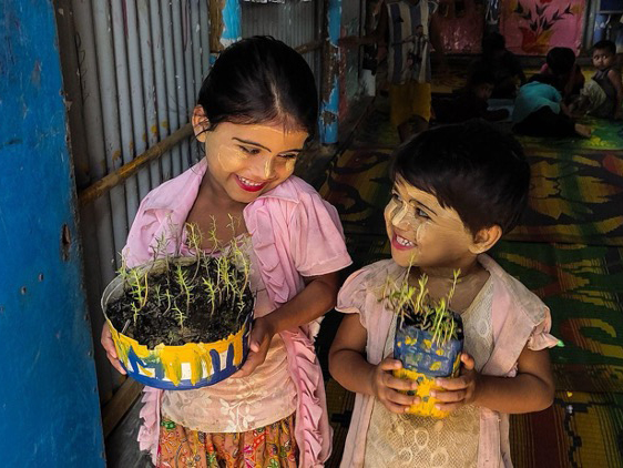 Two children holding plants.