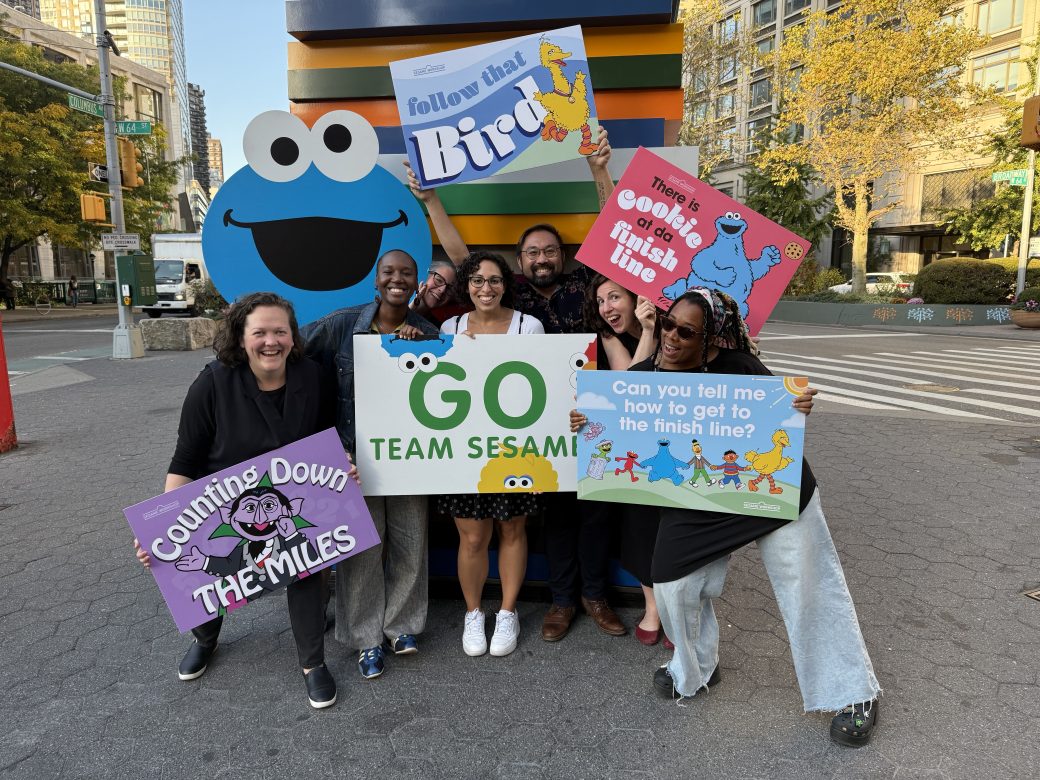 Group holding signs supporting marathon runners.