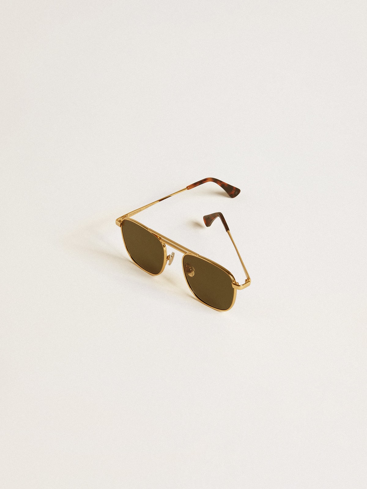 Aviator style sunglasses with gold frame and green lenses 